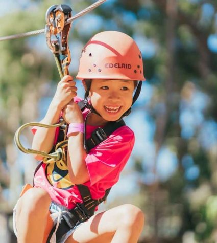 MicrosoftTeams-image (1) (2) child on a zipline at a camp for cancer patients and families